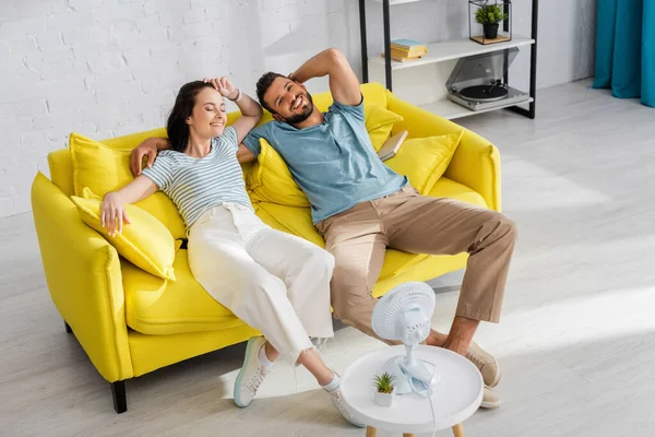 Foyer Sélectif Couple Souriant Assis Sur Canapé Près Ventilateur Électrique — Photo
