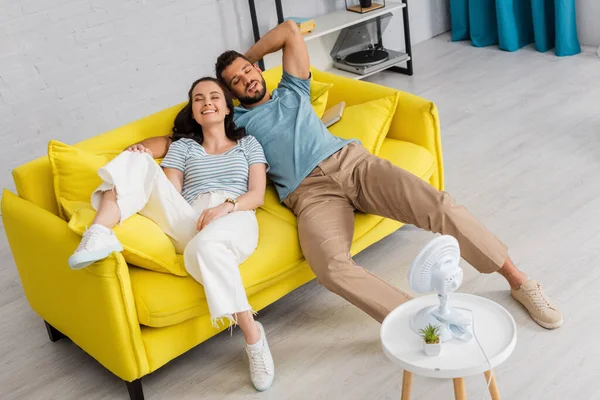 Selective Focus Positive Couple Lying Couch Closed Eyes Electric Fan — Stock Photo, Image