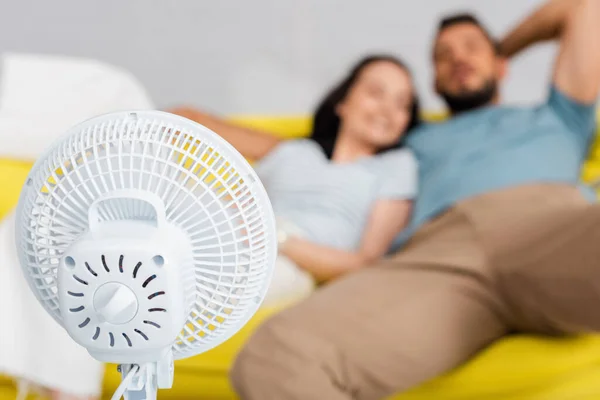 Foco Seletivo Ventilador Elétrico Perto Jovem Casal Sentado Sofá — Fotografia de Stock