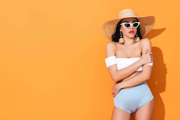 Stylowa Dziewczyna Kostiumie Kąpielowym Okularach Przeciwsłonecznych Słomkowym Kapeluszu Stojąca Pomarańczowym — Zdjęcie stockowe