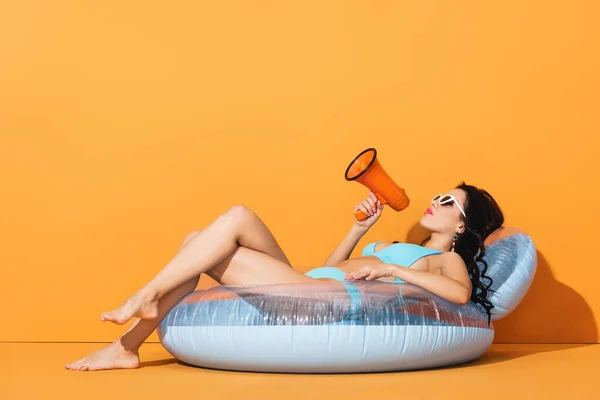 Barefoot Woman Sunglasses Swimwear Lying Inflatable Ring Holding Megaphone Orange — Stock Photo, Image