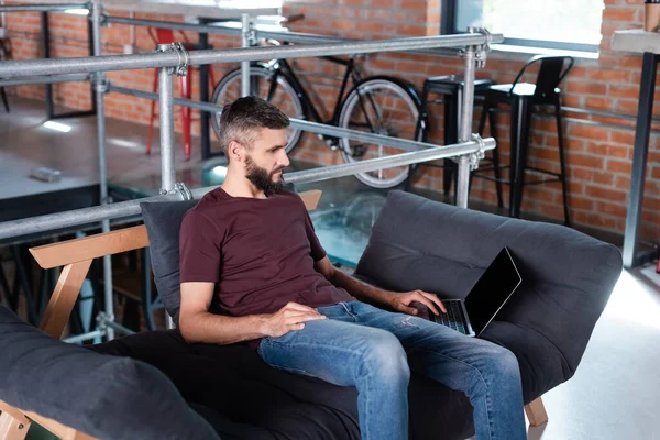 Bonito Empresário Sentado Sofá Usando Laptop Com Tela Branco Escritório — Fotografia de Stock