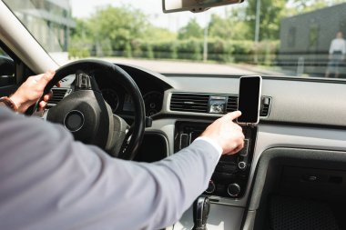 Otomobil kullanırken akıllı telefon kullanan işadamının kırpılmış görüntüsü  