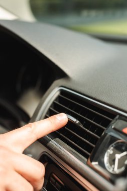 Arabadaki havalandırma sistemini ayarlayan adamın görüntüsü. 