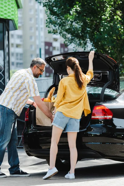 Hombre Sonriente Poniendo Bolsa Compras Con Comida Maletero Del Coche — Foto de Stock