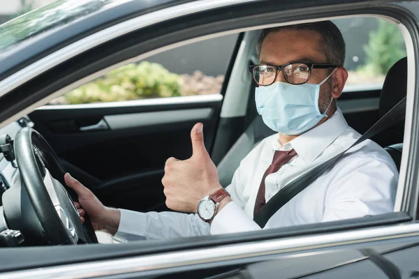 Selective Focus Businessman Medical Mask Showing Thumb While Driving Auto — Stock Photo, Image