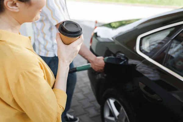Oříznutý Pohled Ženu Drží Kávu Jít Zatímco Manžel Tankování Auto — Stock fotografie