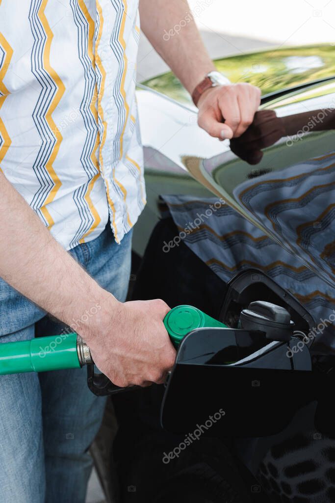 Cropped view of man fueling auto on gas station 