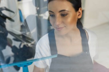 Ofisteki cam camlarını temizlerken cam sapını kullanarak çekici temizleyicinin seçici odak noktası 
