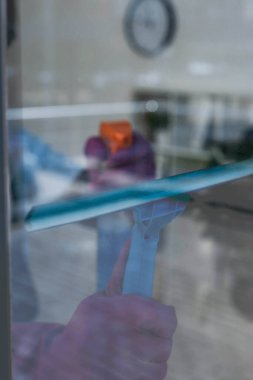 Pencerede cam tutacağı ve deterjan kullanarak temizleyicinin seçici odağı 