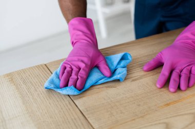 Afro-Amerikan ticari temizlik işçisi, ofis temizleme masasında bez parçasıyla. 