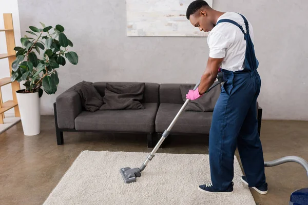 Afroamerikanische Reinigungskraft Overalls Und Gummihandschuhen Putzt Teppich Während Der Arbeit — Stockfoto