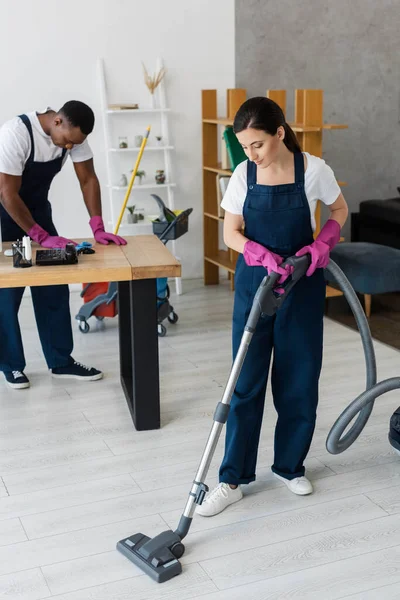 Selective Focus Attractive Cleaner Vacuuming Floor African American Colleague Rag — Stock Photo, Image