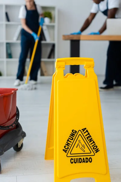 Selective Focus Wet Floor Sign Attention Lettering Multiethnic Cleaners Working — Stock Photo, Image