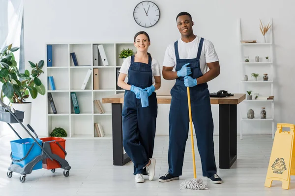 Multicultural Cleaners Rag Mop Smiling Camera Wet Floor Sign Cleaning — Stock Photo, Image