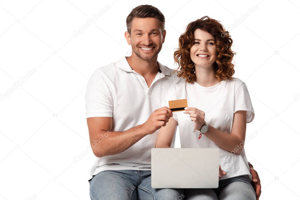 cheerful man with laptop and curly wife holding credit card isolated on white 