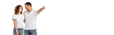 Mutlu adam, beyaz tenli neşeli eşine bakarken parmağıyla işaret ediyor. 