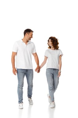 Mutlu kadın ve neşeli adam el ele tutuşup, beyaz üzerinde yürürken birbirlerine bakıyorlar. 