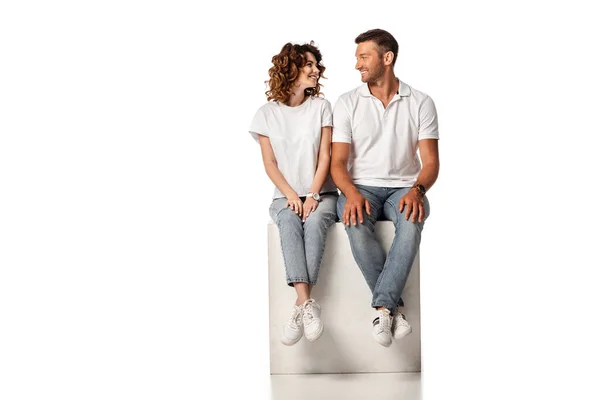 Cheerful Couple Smiling Looking Each Other While Sitting Cube White — Stock Photo, Image