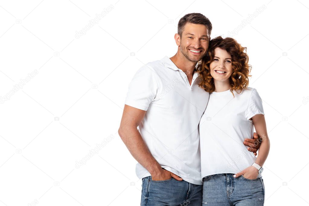 happy man standing with hand in pocket while hugging cheerful woman isolated on white 