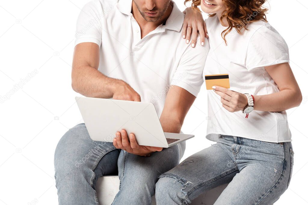 cropped view of happy woman holding credit card near man with laptop isolated on white