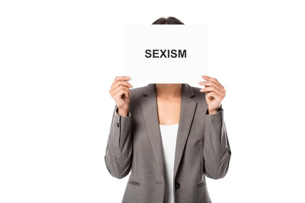 女商人一边蒙着脸 一边拿着写有性别歧视字样的标语牌 用白色隔开 — 图库照片
