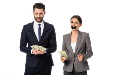 İş kadınının yanında para tutan işadamının ağzında bantla beyazların üzerinde tek başına duran.