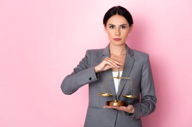 Çekici iş kadını pembe, cinsiyet eşitliği kavramında terazi tutuyor. 