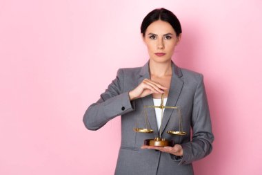 attractive businesswoman holding scales on pink, gender equality concept  clipart