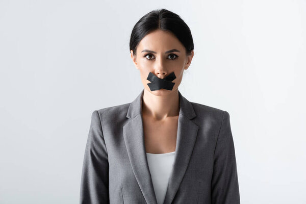 businesswoman with scotch tape on mouth standing isolated on white