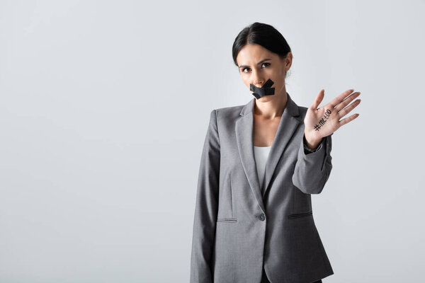 businesswoman with scotch tape on mouth showing hand with me too lettering isolated on white, gender inequality concept