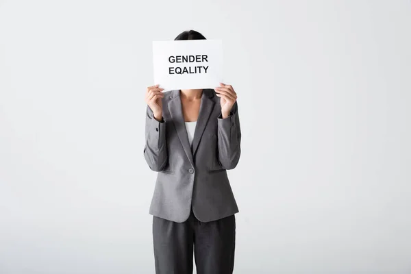 女商人蒙着脸 拿着标语牌 上面写着两性平等的字样 用白色隔开 — 图库照片