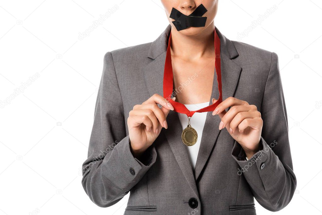 cropped view of businesswoman with scotch tape on mouth touching ribbon with medal isolated on white 