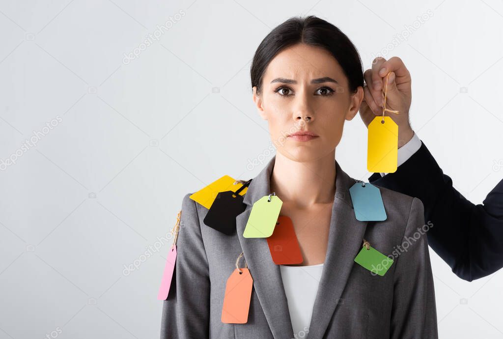 businessman putting label on beautiful businesswoman isolated on white, gender inequality concept
