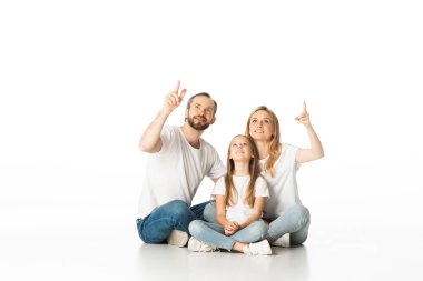 Mutlu aile bacak bacak üstüne atmış, bembeyaz yerde oturuyor.