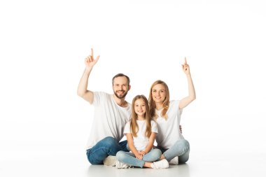 Mutlu aile bacak bacak üstüne atmış, bembeyaz yerde oturuyor.