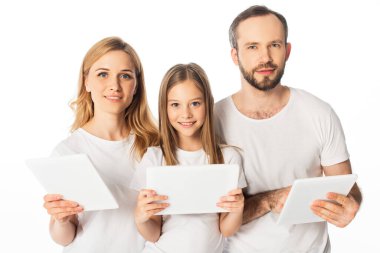 Beyaz tişörtlü gülümseyen aile beyaza izole edilmiş dijital tabletler kullanıyor.