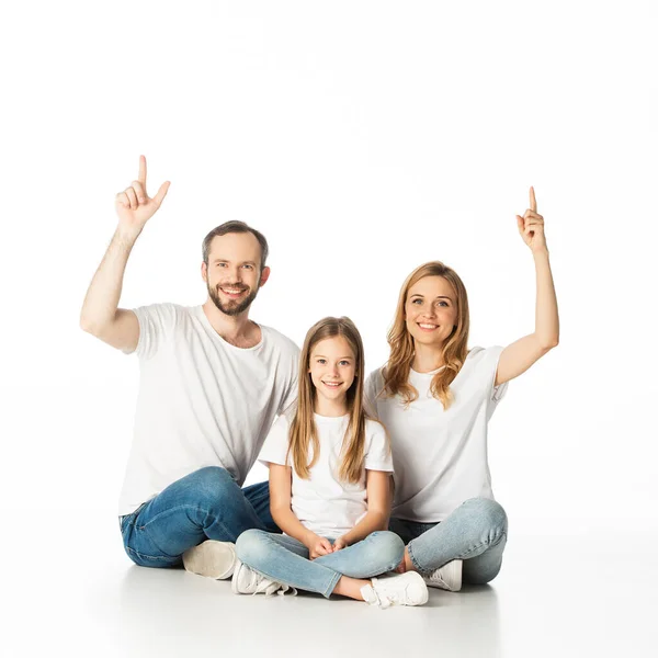 Mutlu aile bacak bacak üstüne atmış, bembeyaz yerde oturuyor.