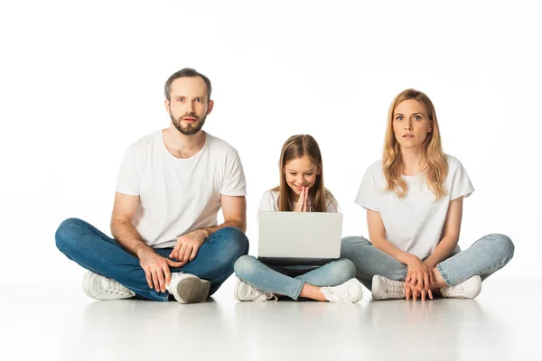 Chockerade Föräldrar Sitter Golvet Nära Lycklig Dotter Med Laptop Isolerad — Stockfoto