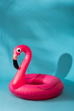 Mavi arka planda pembe şişirilebilir flamingo