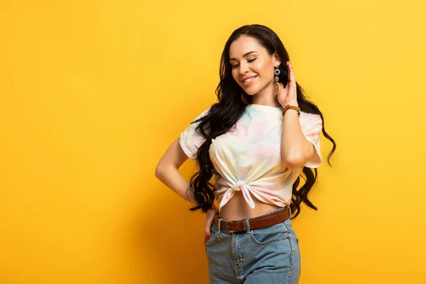 Chica Morena Feliz Tocando Pelo Sobre Fondo Amarillo —  Fotos de Stock
