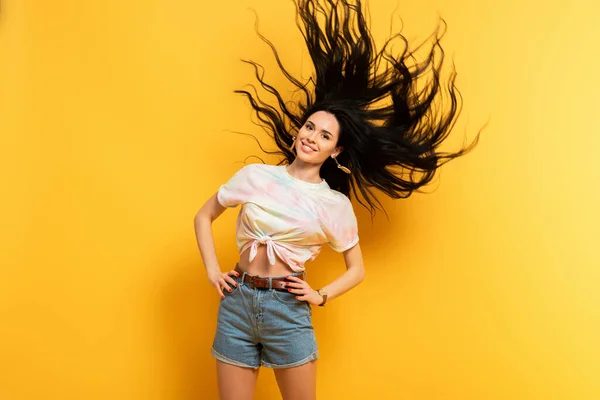 Happy Brunette Girl Waving Hair Yellow Background — Stock Photo, Image