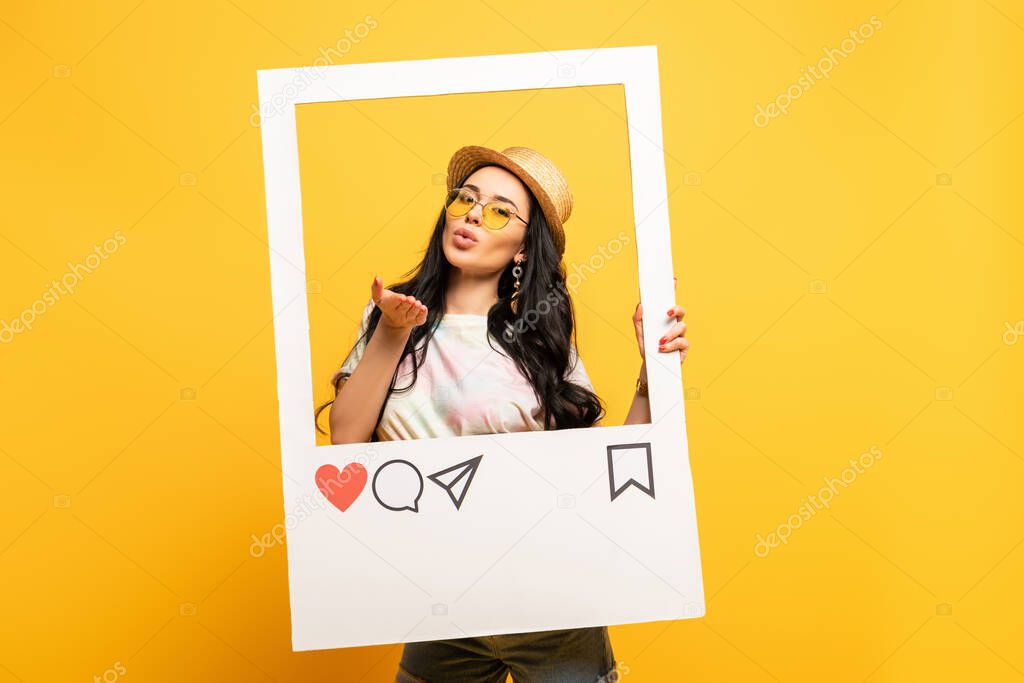 brunette girl in summer outfit posing blowing kiss in social network frame on yellow background