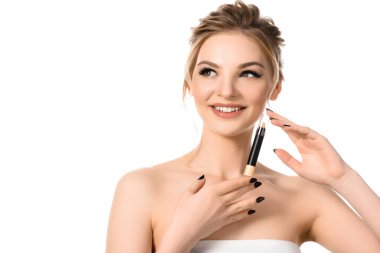 smiling beautiful blonde woman with makeup and black nails holding stick concealer isolated on white clipart
