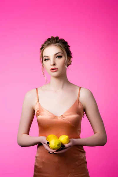Wanita Pirang Cantik Elegan Memegang Lemon Matang Terisolasi Pada Merah — Stok Foto