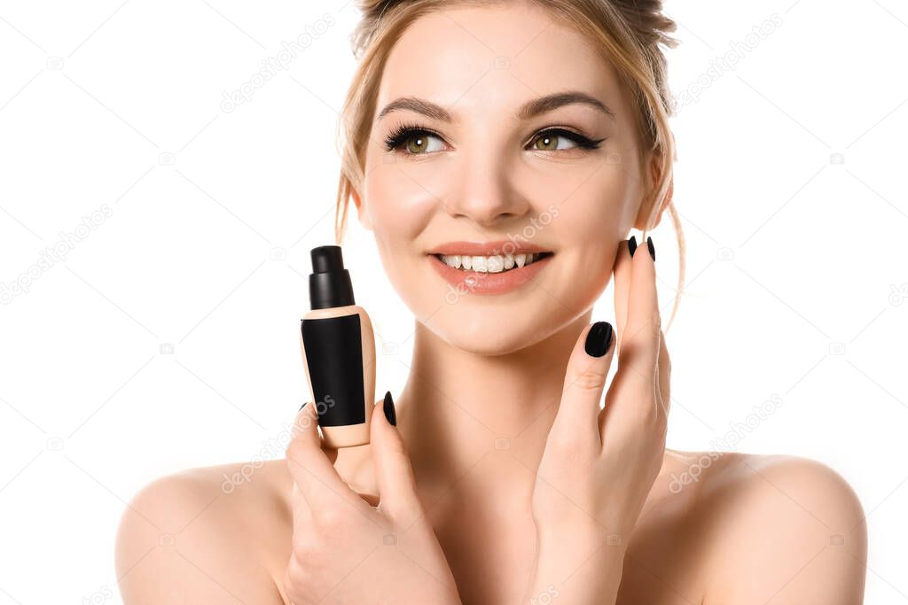 smiling naked beautiful blonde woman with makeup and black nails holding face foundation isolated on white