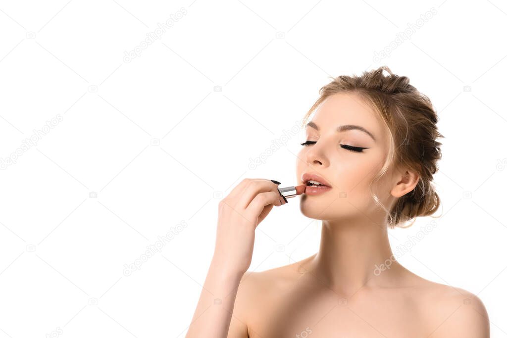 naked beautiful blonde woman with closed eyes applying beige lipstick isolated on white