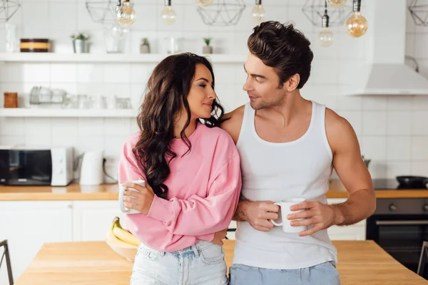 Young Couple Holding Cups Coffee Looking Each Other Kitchen — Stock Photo, Image