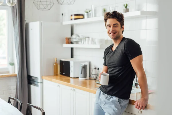 Foco Seletivo Homem Bonito Sorrindo Para Câmera Enquanto Segurando Xícara — Fotografia de Stock