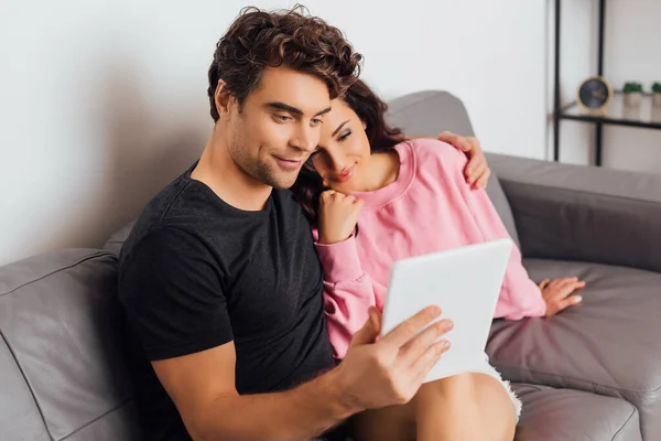 リビングルームでデジタルタブレットを使用して若いカップルの選択的な焦点 — ストック写真